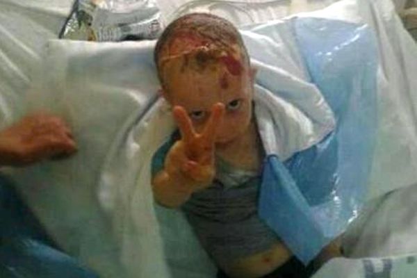 Filistinli çocuktan sedye üzerinde zafer pozu