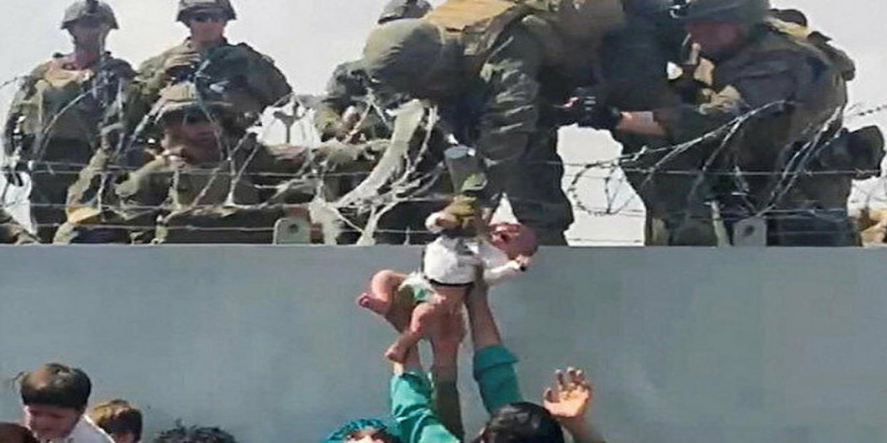 Kabil'deki havalimanında duvarın üzerinden ABD askerlerine verilirken görüntülenen bebek ailesine kavuştu