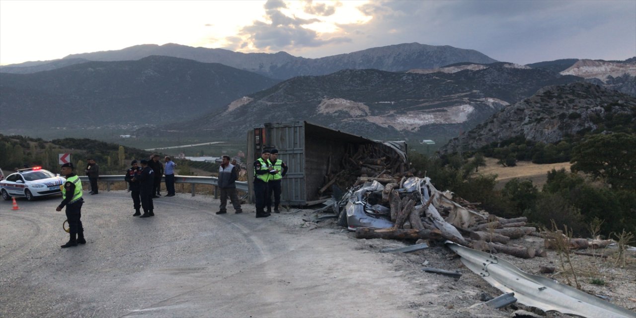Isparta'da odun yüklü tır otomobilin üzerine devrildi.