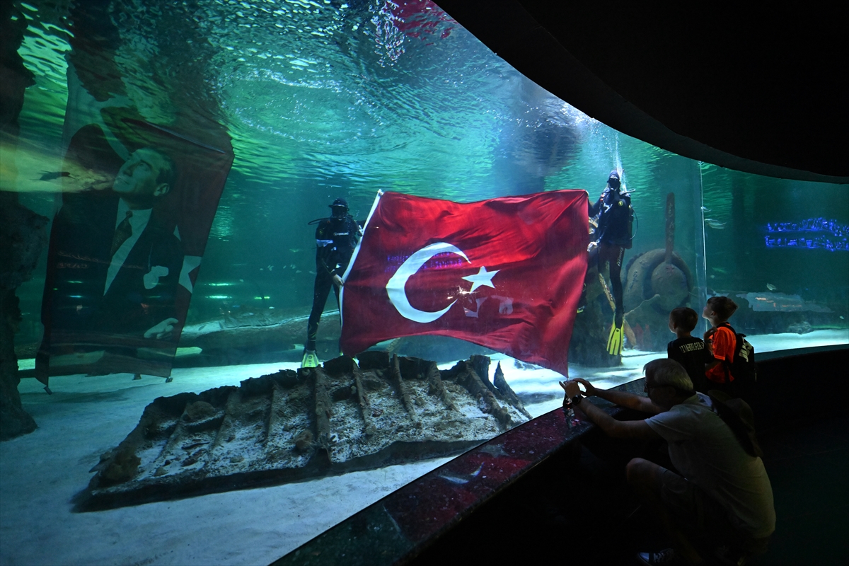 Antalya'da köpek balıklarıyla dolu akvaryumda bayrak açarak 30 Ağustos'u kutladılar