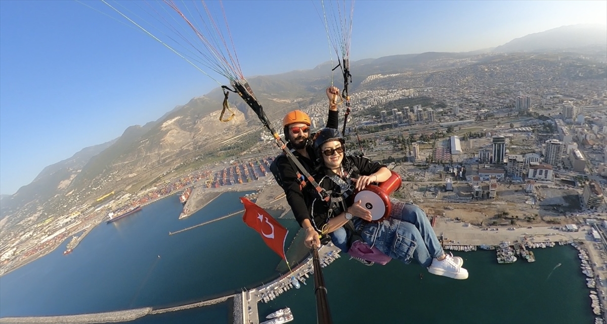 Hatay'da yamaç paraşütüyle atlayan kadın gökyüzünde darbuka çaldı