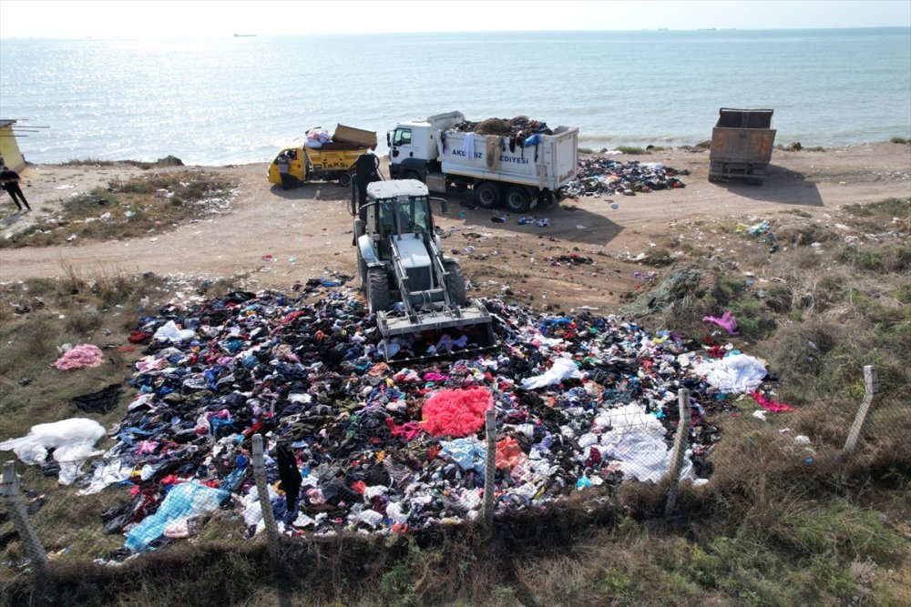 Mersin'de deniz kıyısına atılan giysi ve tekstil atıkları iş makineleriyle toplandı