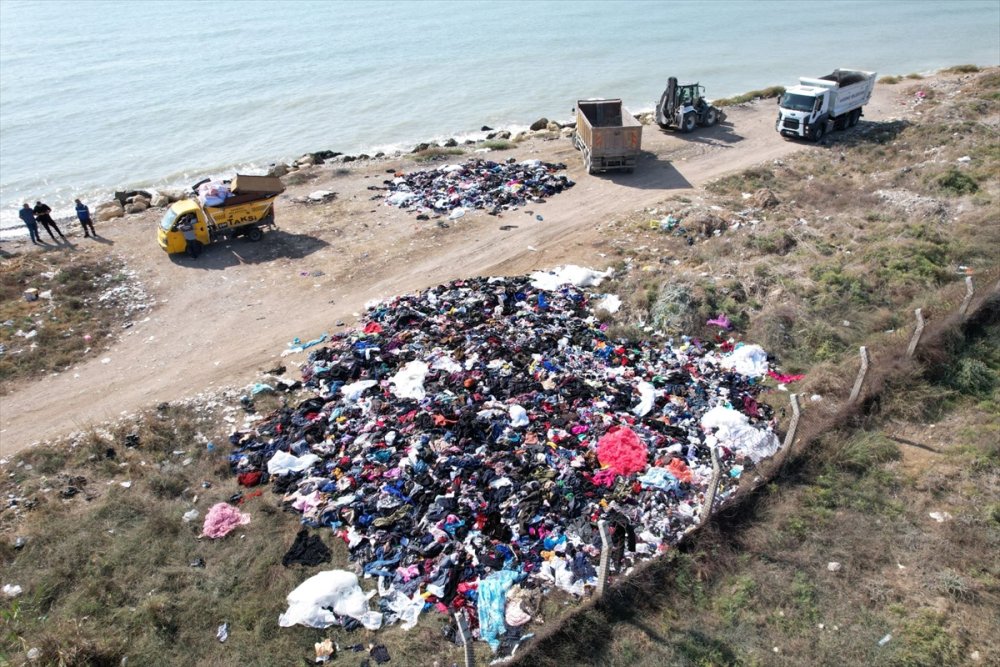 Mersin'de deniz kıyısına atılan giysi ve tekstil atıkları iş makineleriyle toplandı